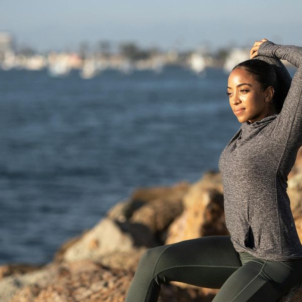 Person stretching outdoors during a beautiful sunrise.